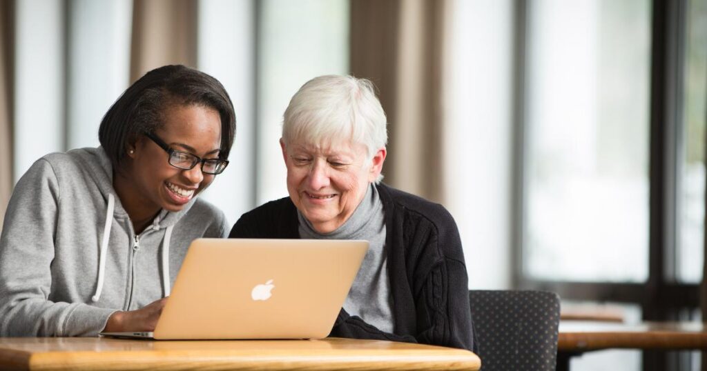 Caregiver helping senior with technology